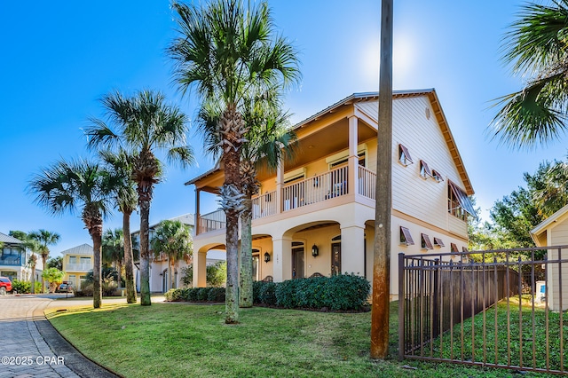 mediterranean / spanish-style home with a balcony and a front lawn