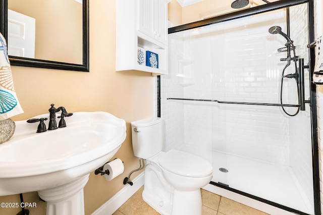 bathroom with toilet, tile patterned floors, a shower with shower door, and sink