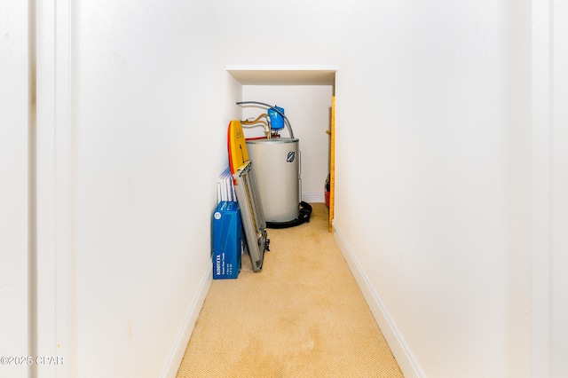 hallway featuring light colored carpet and water heater