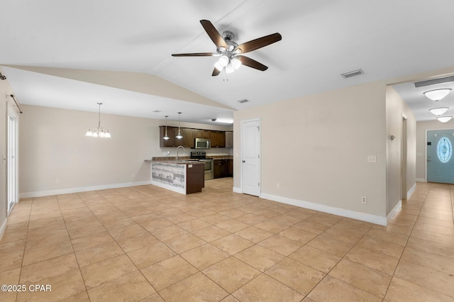 unfurnished living room featuring ceiling fan with notable chandelier, light tile patterned flooring, sink, and vaulted ceiling