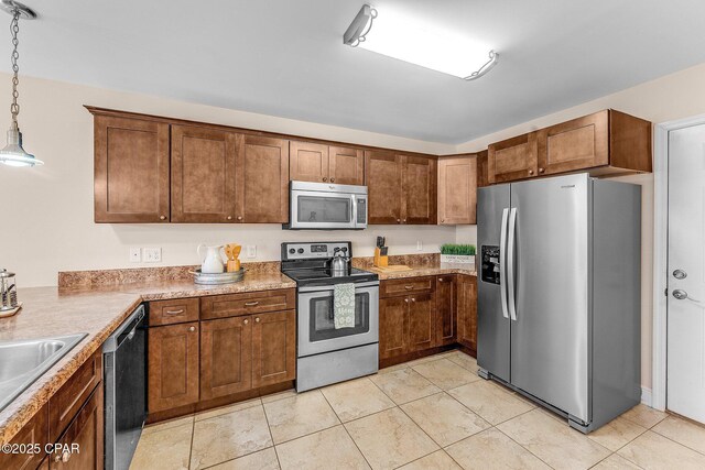 kitchen with sink, hanging light fixtures, dark brown cabinets, kitchen peninsula, and stainless steel appliances