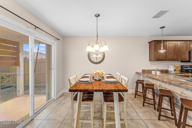 kitchen with pendant lighting, sink, appliances with stainless steel finishes, dark brown cabinets, and kitchen peninsula