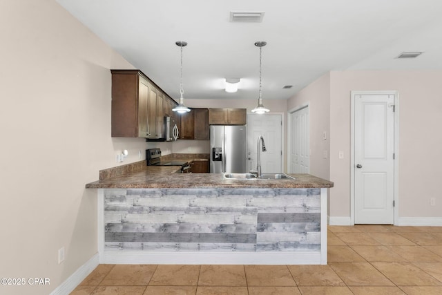 kitchen featuring sink, hanging light fixtures, light tile patterned floors, kitchen peninsula, and stainless steel appliances