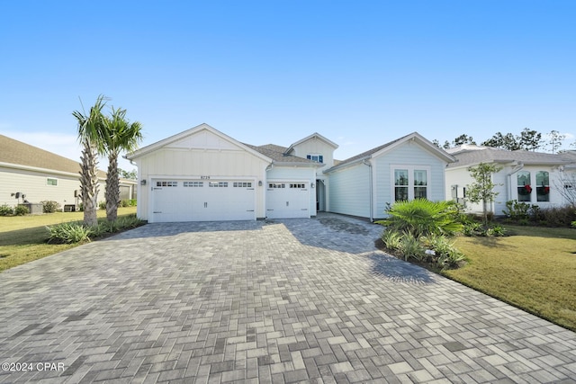 single story home featuring a front lawn and a garage