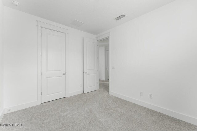 unfurnished room featuring light carpet