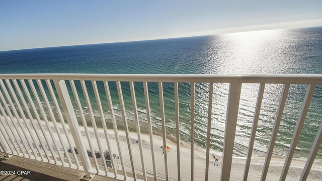 balcony featuring a water view and a beach view