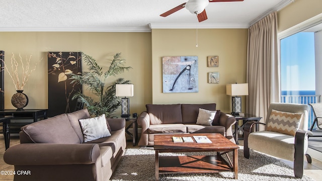 living room featuring crown molding, a water view, a textured ceiling, and ceiling fan