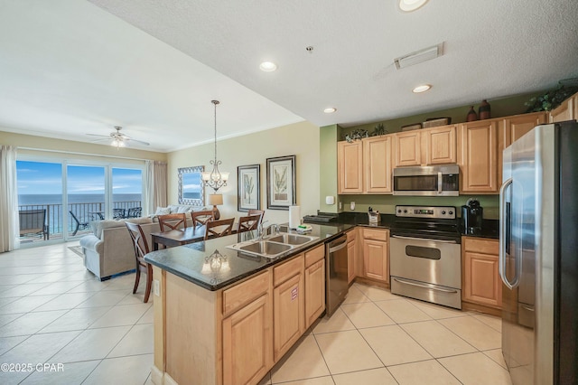 kitchen with pendant lighting, a water view, sink, kitchen peninsula, and stainless steel appliances