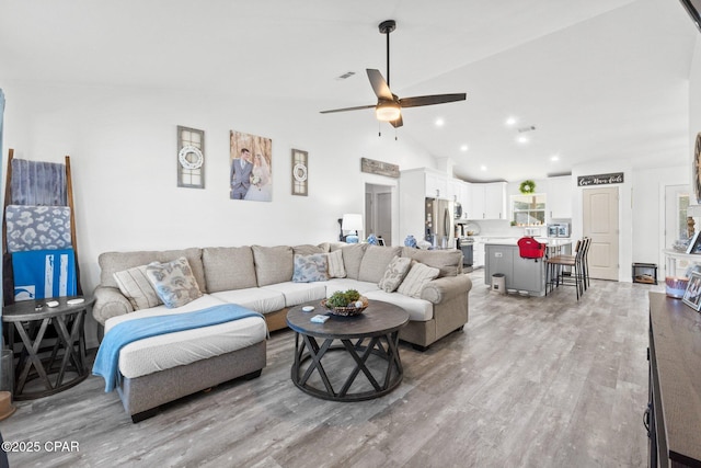 living room featuring ceiling fan, light hardwood / wood-style flooring, and high vaulted ceiling