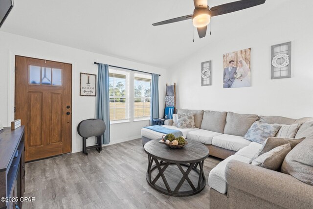 living room with hardwood / wood-style floors, ceiling fan, and lofted ceiling