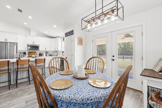 dining area with ceiling fan, french doors, light hardwood / wood-style floors, and lofted ceiling