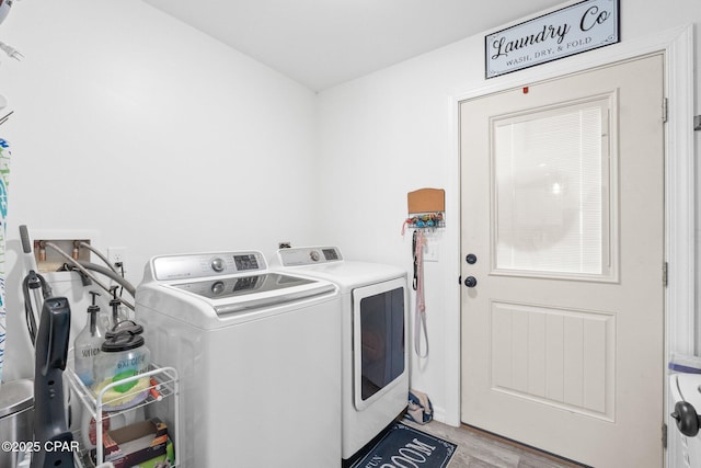 laundry area featuring washer and dryer and light hardwood / wood-style floors