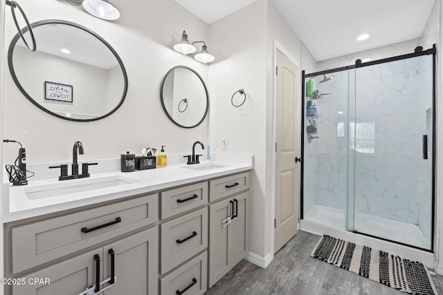 bathroom with vanity, wood-type flooring, and a shower with door