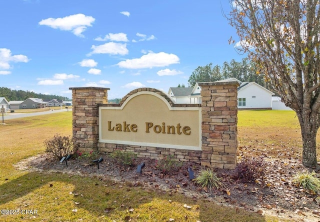 community / neighborhood sign featuring a yard