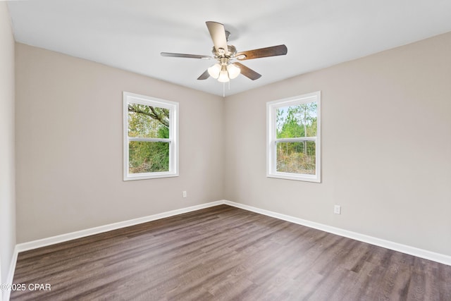 spare room featuring ceiling fan, dark hardwood / wood-style flooring, and a healthy amount of sunlight