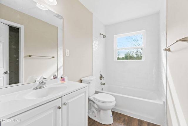 full bathroom with hardwood / wood-style floors, vanity, toilet, and washtub / shower combination