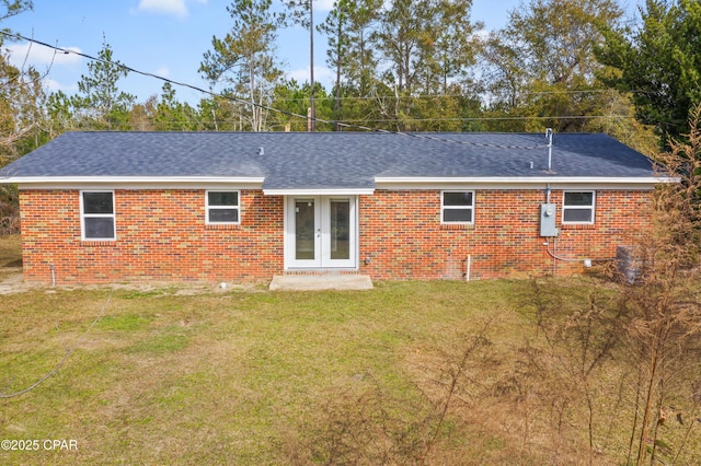 back of property featuring french doors and a lawn