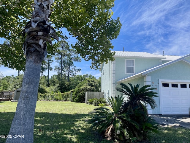 view of side of property with a yard and a garage