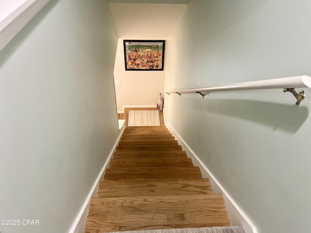 stairs featuring hardwood / wood-style floors