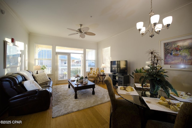 living room with ceiling fan with notable chandelier, hardwood / wood-style flooring, and ornamental molding