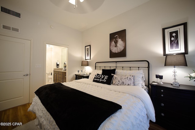 bedroom featuring ceiling fan, lofted ceiling, ensuite bath, and dark hardwood / wood-style floors