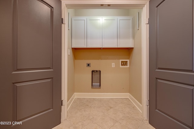 clothes washing area featuring hookup for an electric dryer, cabinets, and washer hookup