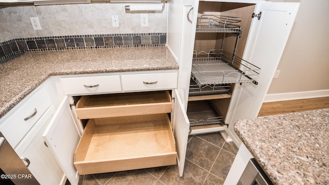 8700 Front Beach Rd Unit 5302, Panama City Beach, FL 32407 - room details featuring white cabinets, baseboards, light stone counters, and tasteful backsplash