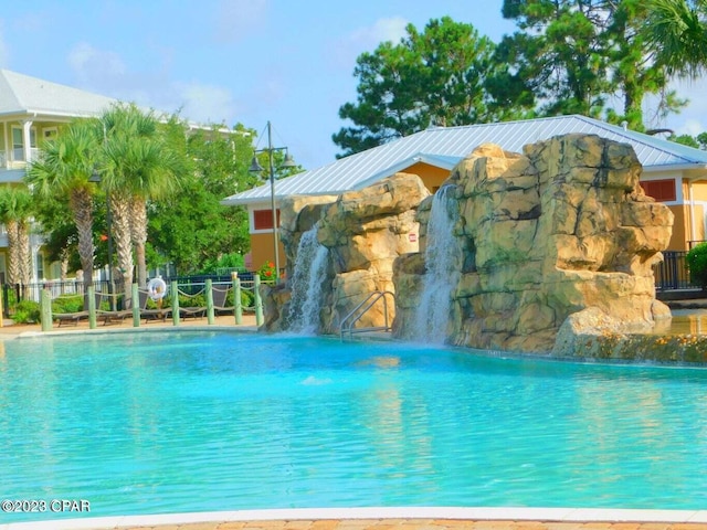 view of swimming pool with pool water feature