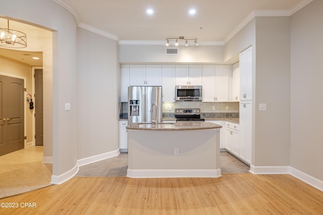 kitchen with light stone countertops, appliances with stainless steel finishes, light wood-type flooring, white cabinets, and an island with sink