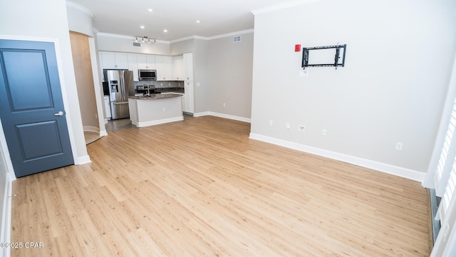 unfurnished living room featuring crown molding, sink, and light hardwood / wood-style flooring