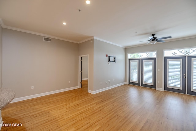 spare room with ceiling fan, light wood-type flooring, ornamental molding, and french doors