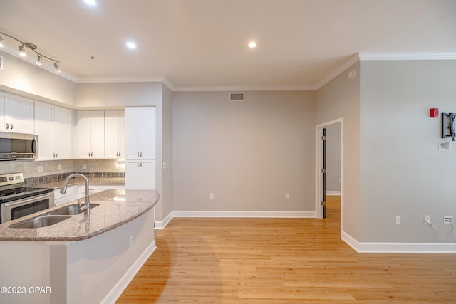 kitchen with light stone countertops, stainless steel appliances, crown molding, sink, and white cabinets