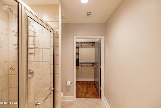 8700 Front Beach Rd Unit 5302, Panama City Beach, FL 32407 - bathroom featuring a shower stall, tile patterned floors, a spacious closet, baseboards, and toilet