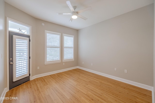 spare room featuring ceiling fan, a healthy amount of sunlight, and light hardwood / wood-style flooring