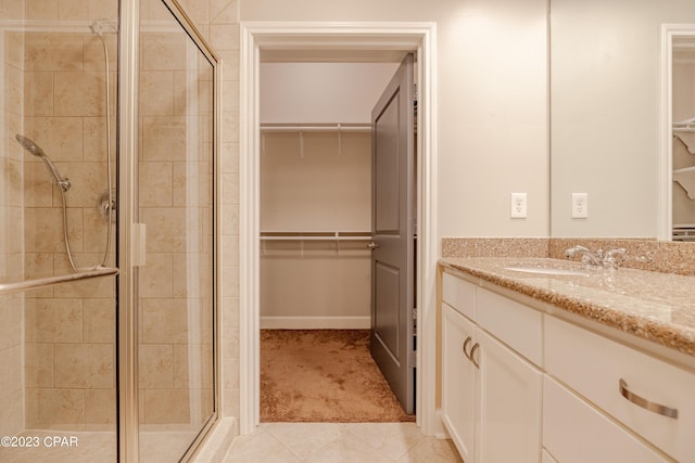 bathroom with tile patterned flooring, vanity, and a shower with shower door