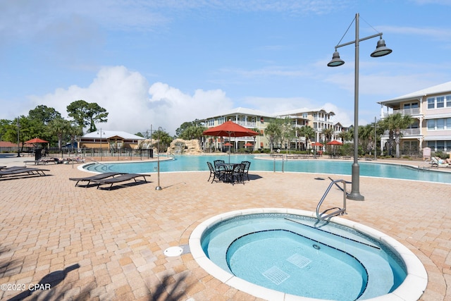 view of swimming pool with a community hot tub and a patio