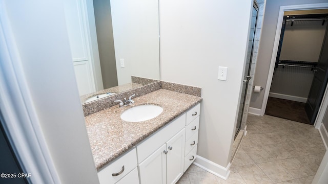 8700 Front Beach Rd Unit 5302, Panama City Beach, FL 32407 - full bath featuring a shower stall, a spacious closet, vanity, baseboards, and tile patterned flooring
