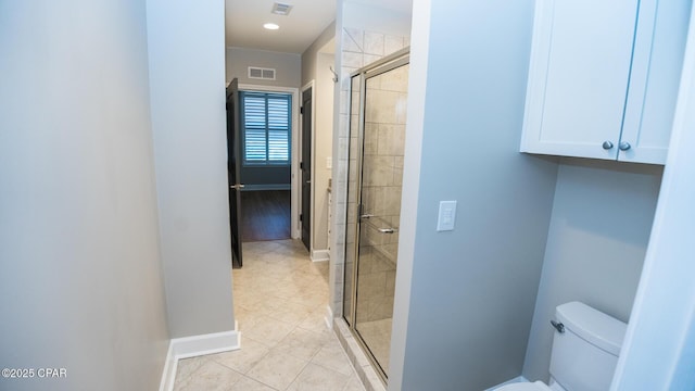 bathroom with tile patterned flooring, an enclosed shower, and toilet