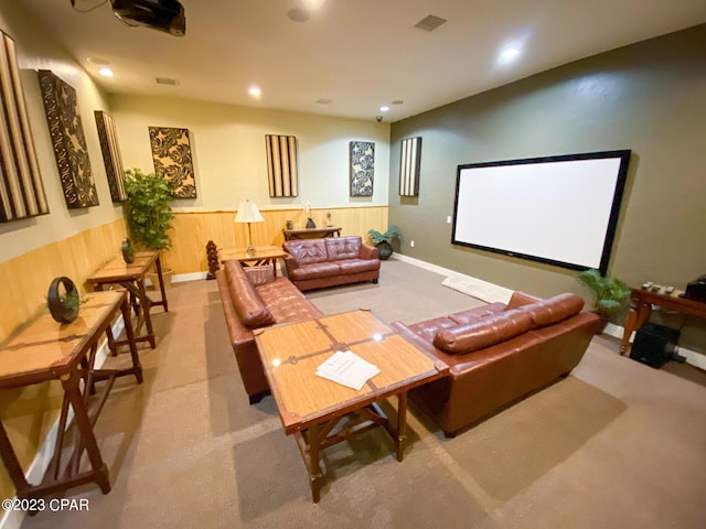 carpeted home theater room with wood walls