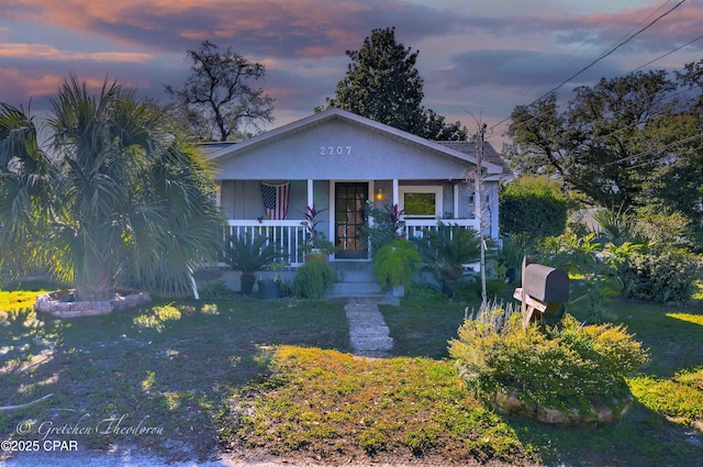 view of front of property featuring a porch and a yard