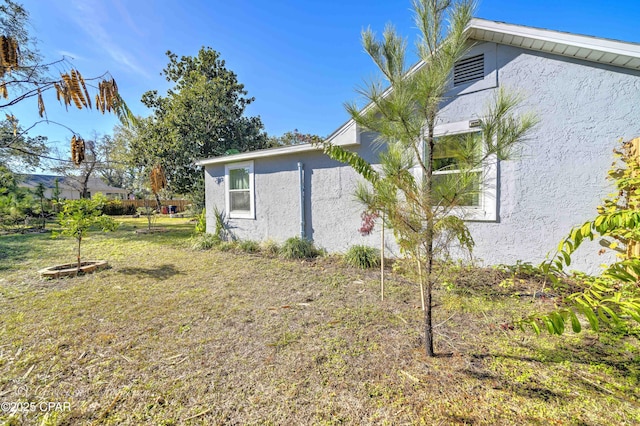 view of side of home with a yard