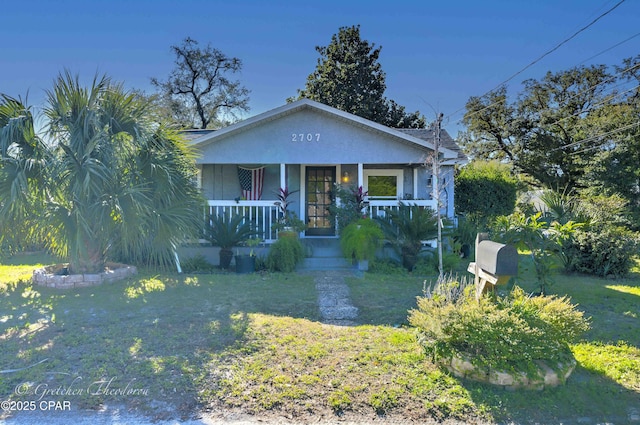 view of front of property featuring a front lawn and covered porch