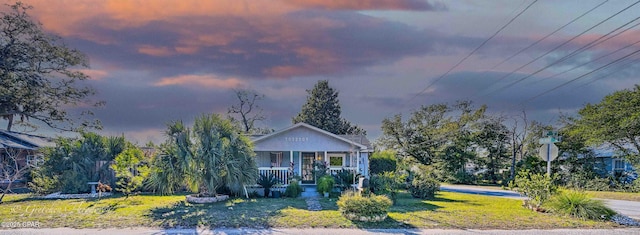 view of front of house featuring a lawn and covered porch