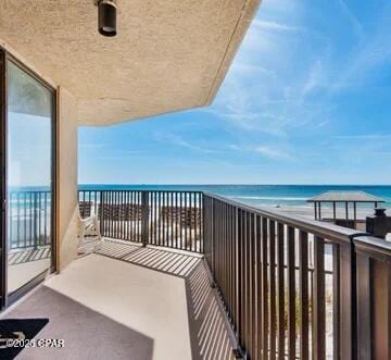 balcony featuring a beach view and a water view