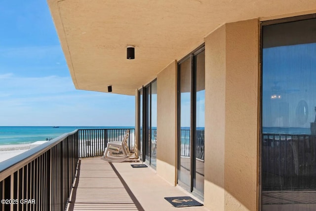 balcony with a beach view and a water view