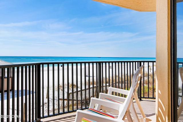 balcony featuring a water view and a beach view