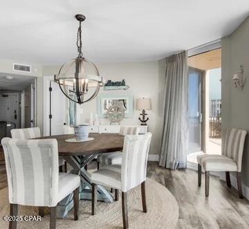 dining room with wood-type flooring and an inviting chandelier