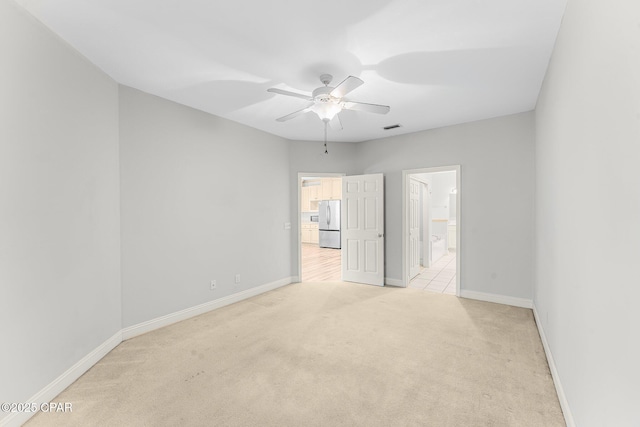 unfurnished room featuring ceiling fan and light carpet