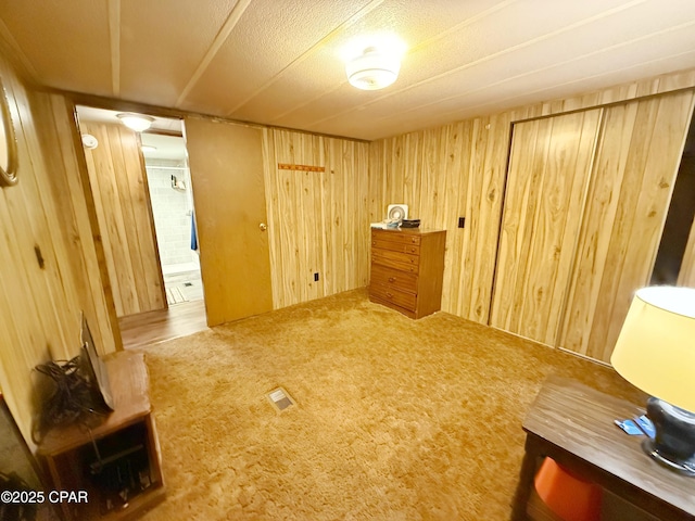 unfurnished room with carpet floors and wooden walls