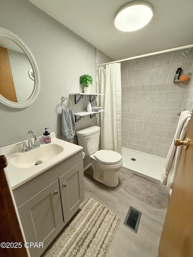 bathroom featuring a shower with curtain, hardwood / wood-style floors, vanity, and toilet